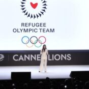 YUSRA MARDINI HIGHLIGHTS THE IMPORTANCE OF THE REFUGEE OLYMPIC TEAM  (PHOTO – OLYMPIC HEROINE YUSRA MARDINI ADDRESSES THE AUDIENCE)